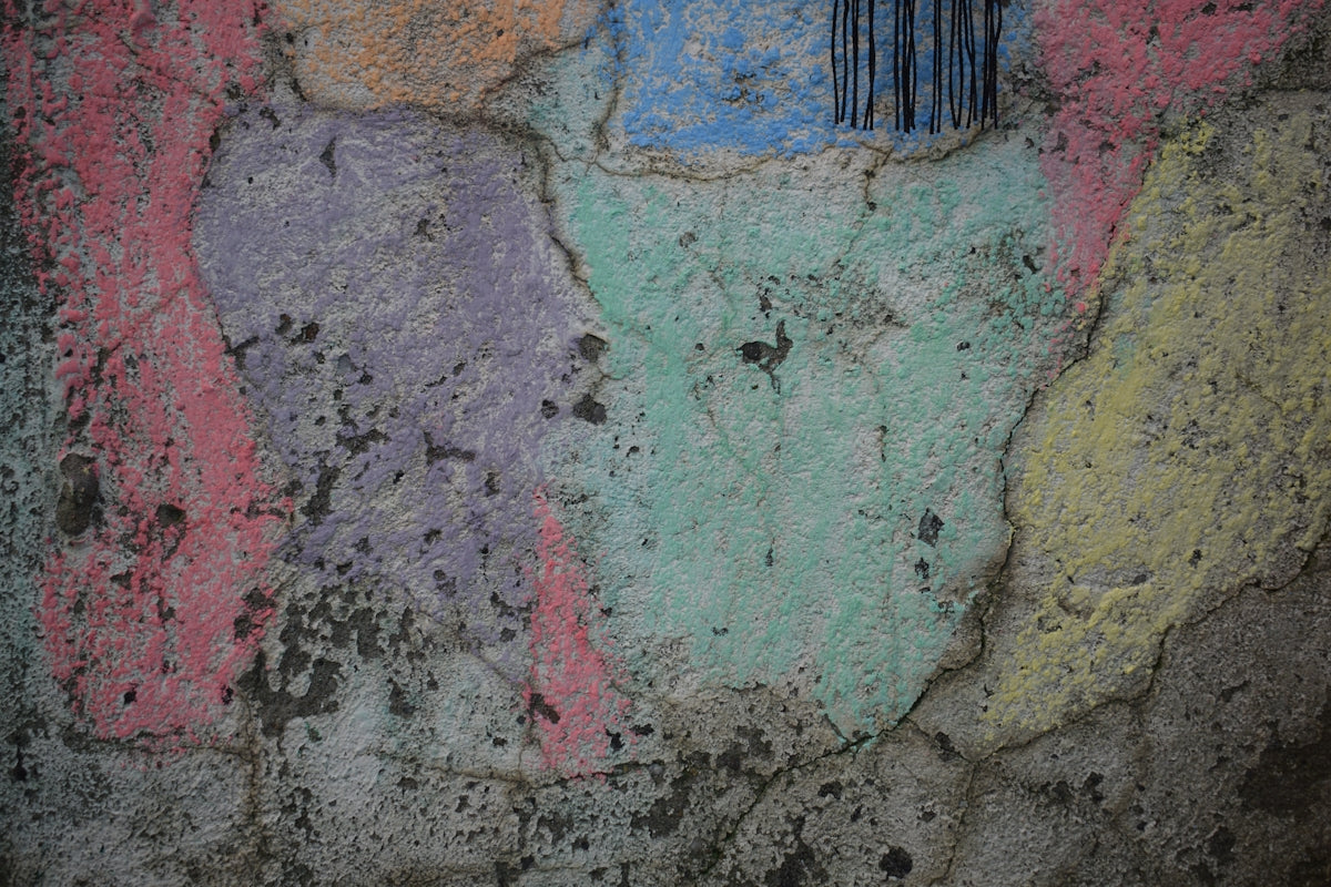 Cracked concrete wall with colorful chalk markings
