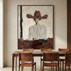 Modern rustic cowboy portrait print adding moody artistic depth to a dining room wall near a wooden side cabinet.