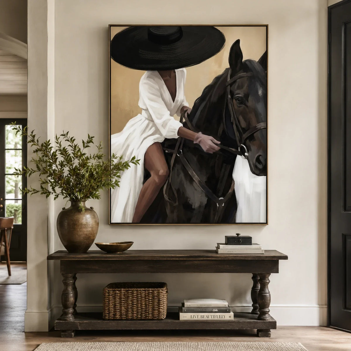 Elegant woman on black horse artwork mounted over a dark walnut entryway console table in a warm sunlit foyer