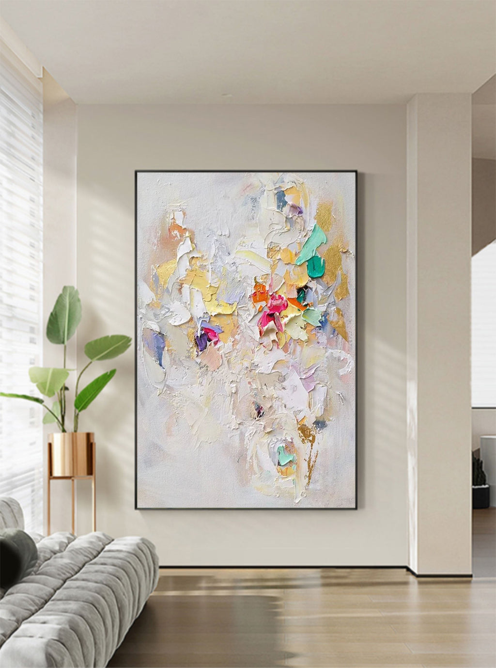 Heavy textured colorful abstract canvas artwork styled above a neutral linen sofa in a bright modern living room