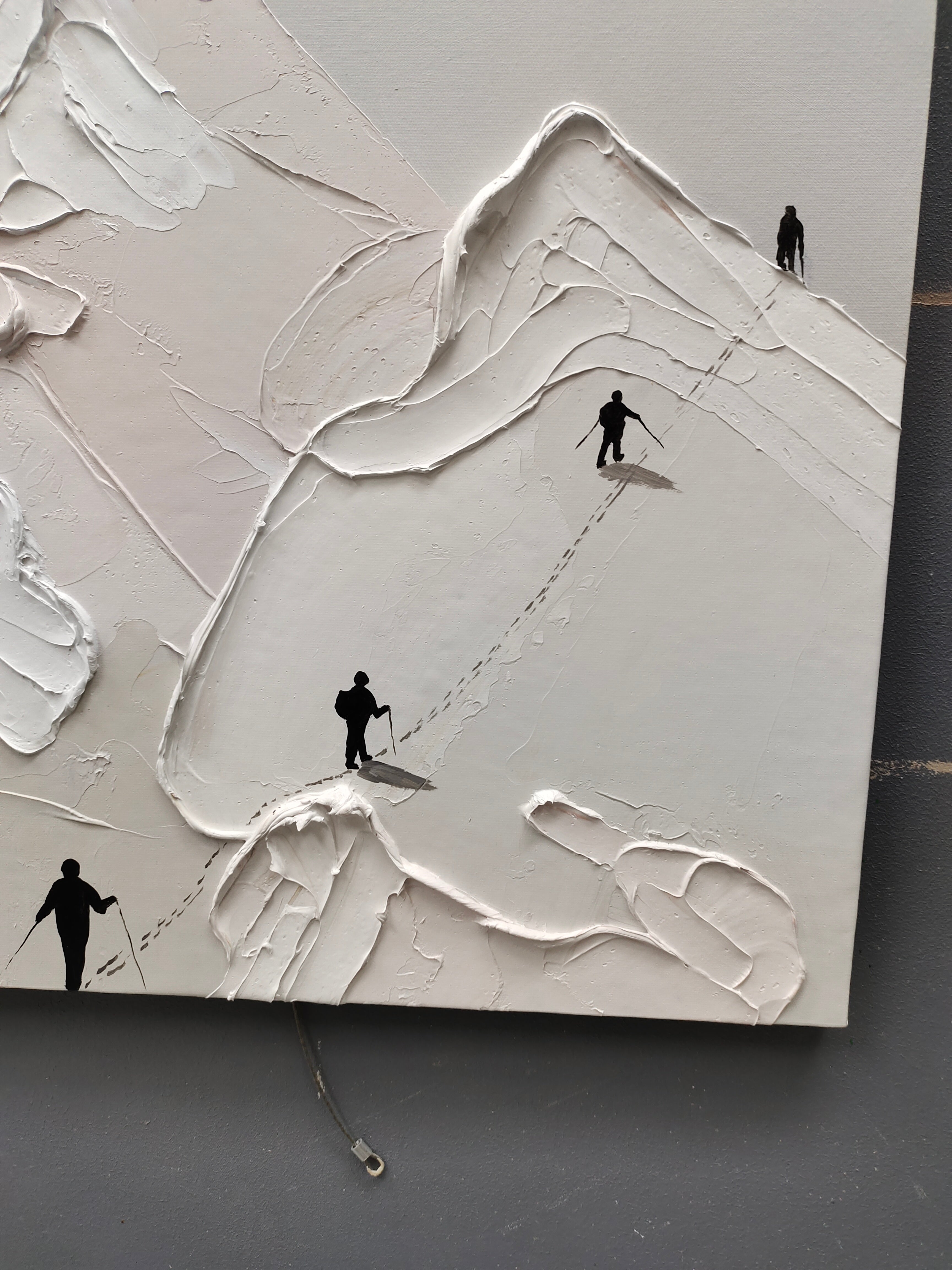 Close-up macro detail of heavy texture plaster artwork showing exquisite palette knife snow ridges and tiny climbers