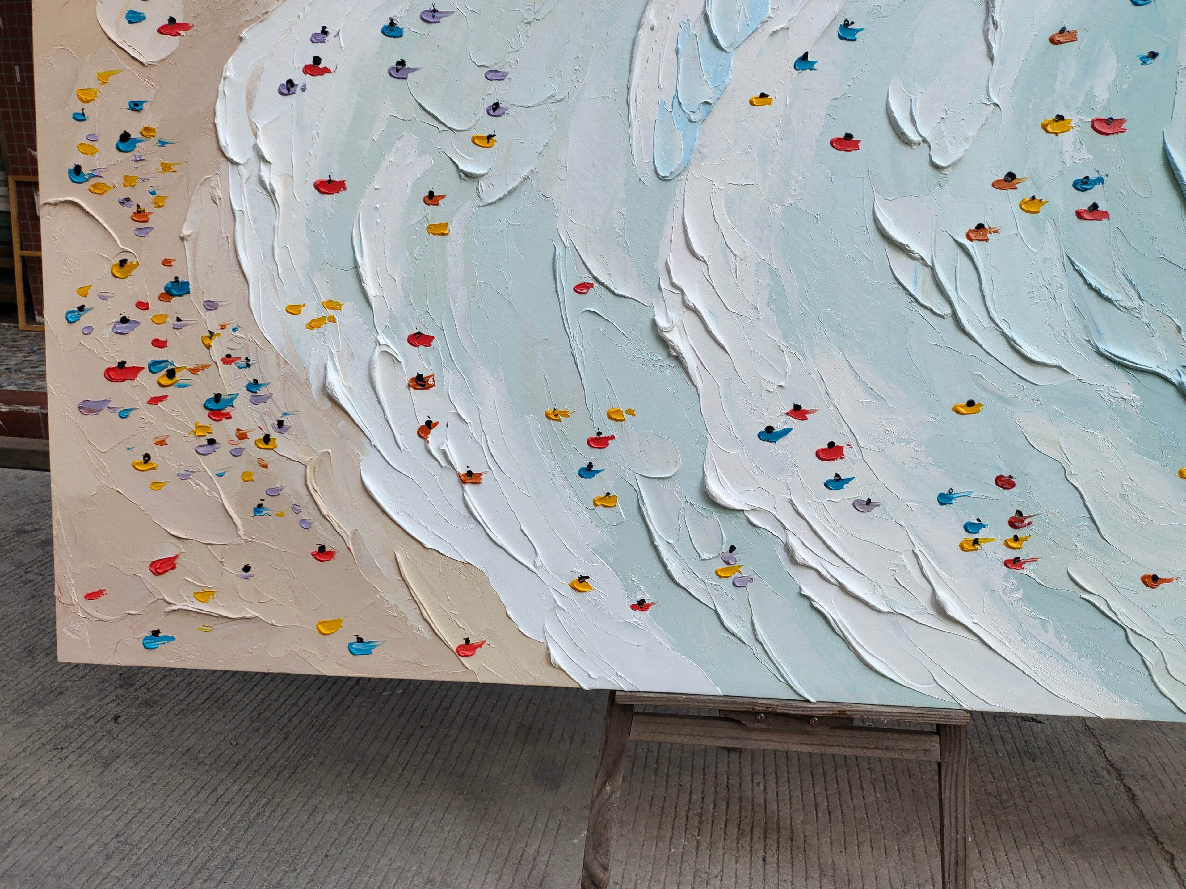 Close-up macro detail of heavy texture plaster artwork showing exquisite palette knife white waves and colorful swimmers