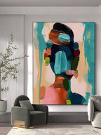 Vibrant abstract woman portrait canvas artwork beautifully framed and hung on a modern minimalist living room wall.