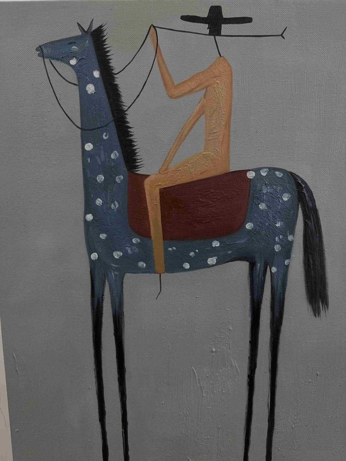 Minimalist equestrian figure artwork mounted over a weathered wooden console table in a bright entryway foyer