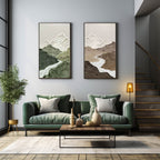 Pair of vertical abstract landscape canvas prints beautifully framed and hung side by side above a living room sofa.
