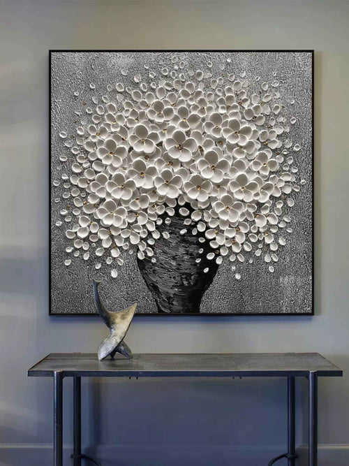 Modern white flower metallic canvas painting styled above a neutral fabric sofa in a luxury living room
