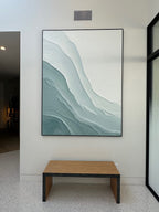 Blue and green Ebb Wabi-Sabi textured wall art is displayed above an entryway stool, part of the modern interior decor.