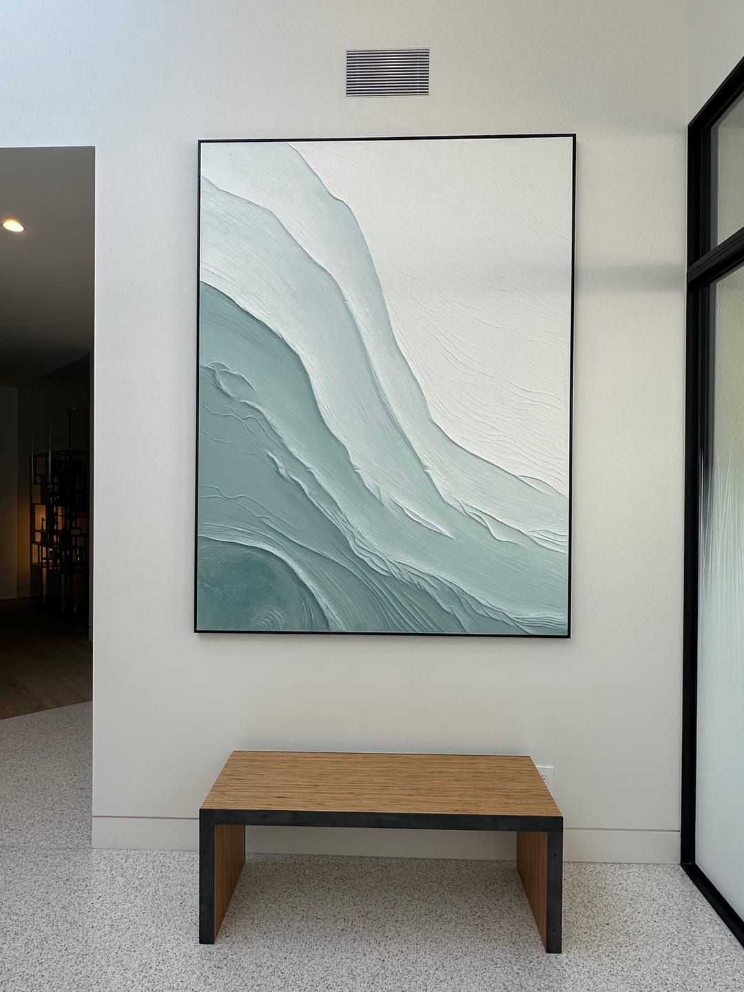 Blue and green Ebb Wabi-Sabi textured wall art is displayed above an entryway stool, part of the modern interior decor.