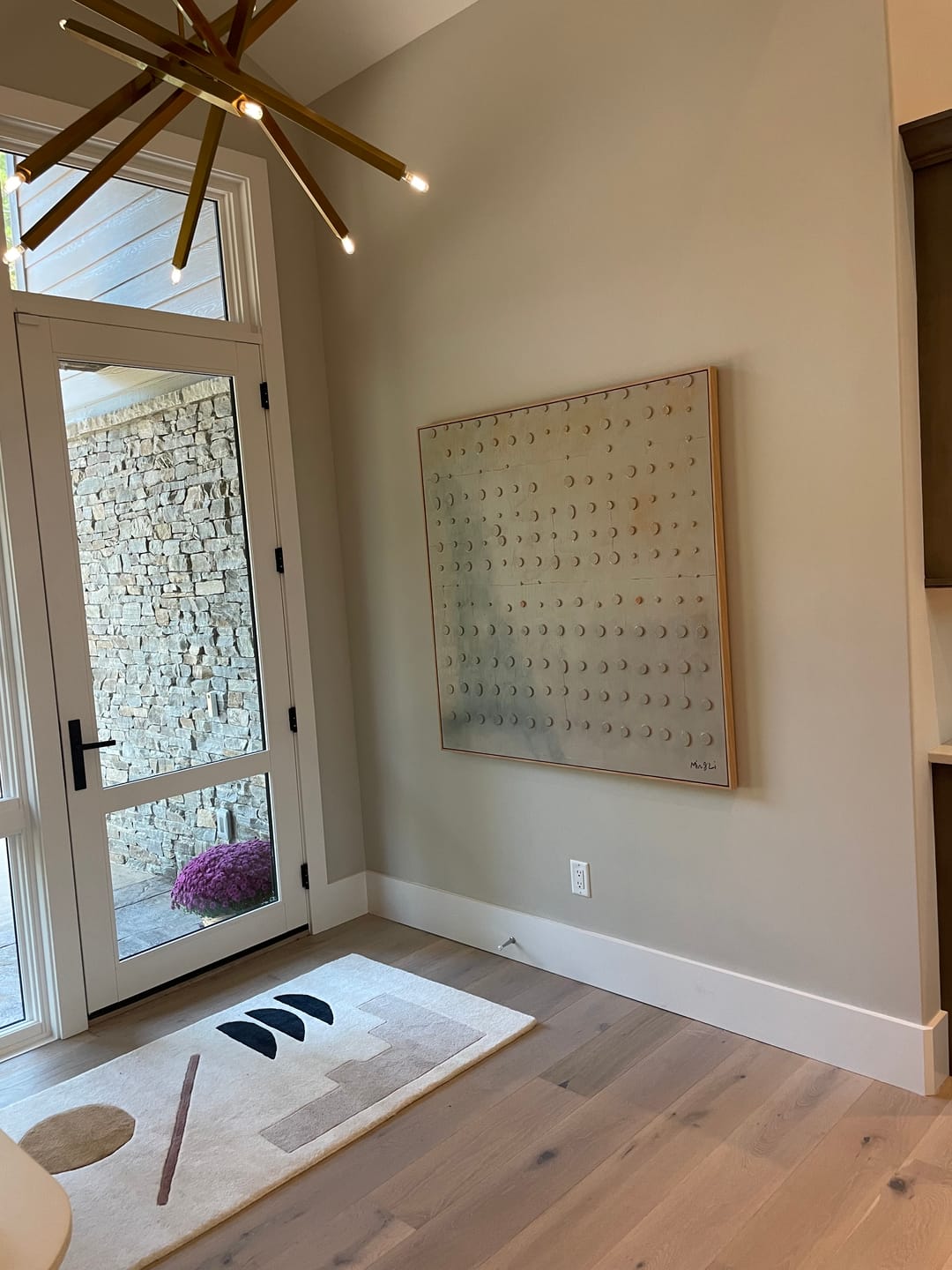 Framed contemporary large abstract beige painting hung in a luxury entryway