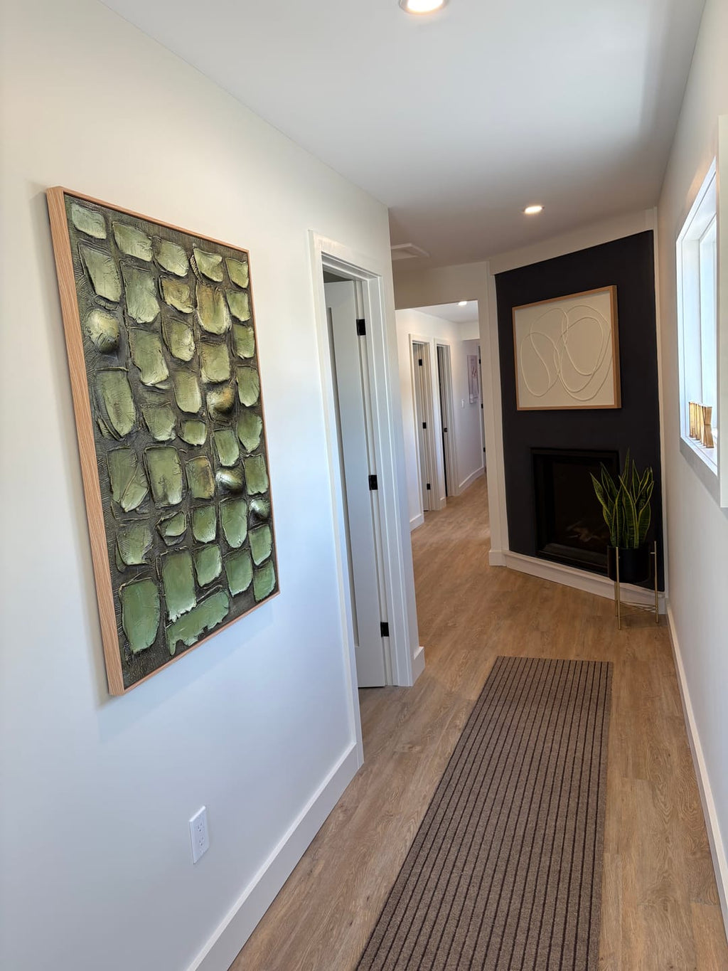 Sophisticated heavy textured abstract foliage artwork adding biophilic design and cozy style to a home hallway.