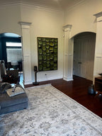 Contemporary textured plant motif art piece enhancing the gallery wall of a sleek living room area.