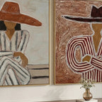 Minimalist textured cowboy and cowgirl canvas art set displayed above the bed frame in a boho bedroom