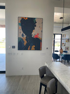 A black abstract portrait plaster wall art painting hangs on the wall of the dining room.
