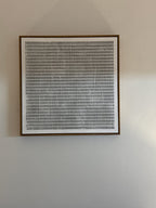 A black and white grid square-framed wall art painting hangs on the wall in the entryway.