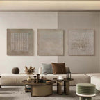 Set of 3 abstract wabi-sabi wall art panels displayed in modern living room above neutral sofa