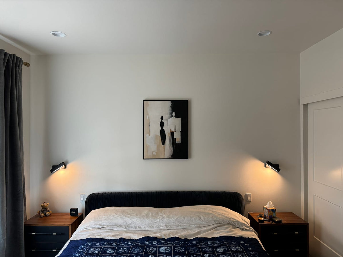 A framed abstract black, white, and beige painting centered above the bed.