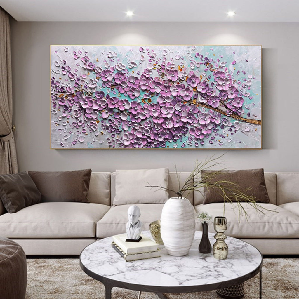 Heavy textured purple floral canvas artwork styled above a neutral cream sofa in a bright modern living room
