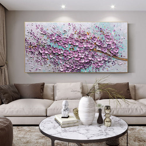 Heavy textured purple floral canvas artwork styled above a neutral cream sofa in a bright modern living room