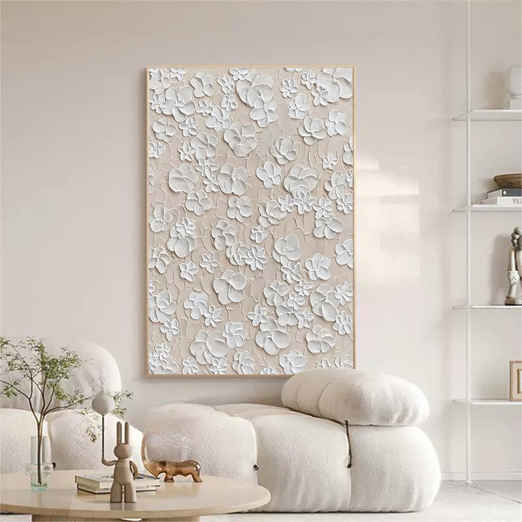 Large white textured floral canvas painting hanging above a minimalist sofa in a modern living room