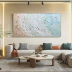 Large abstract ocean beach horizontal painting hanging above a minimalist sofa in a modern living room