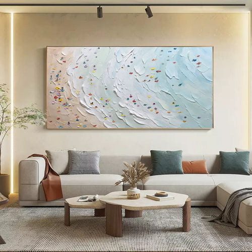 Large abstract ocean beach horizontal painting hanging above a minimalist sofa in a modern living room