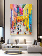 Colorful Mediterranean style streetscape canvas artwork beautifully framed and hung in a modern living room.