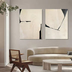 Contemporary black and beige abstract paintings enhancing a sleek, minimalist dining room wall.