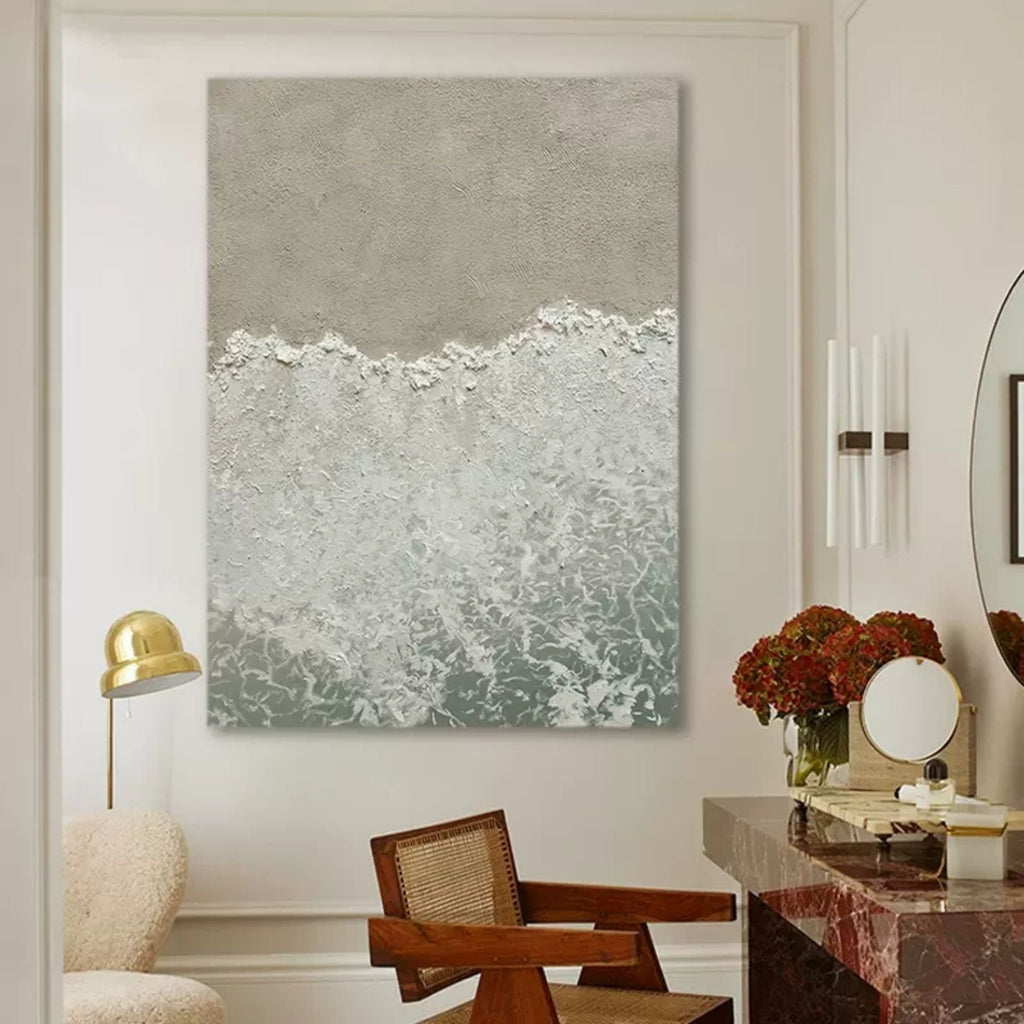 Modern neutral beach sand and ocean painting creating a serene coastal aesthetic over a master bedroom bed.