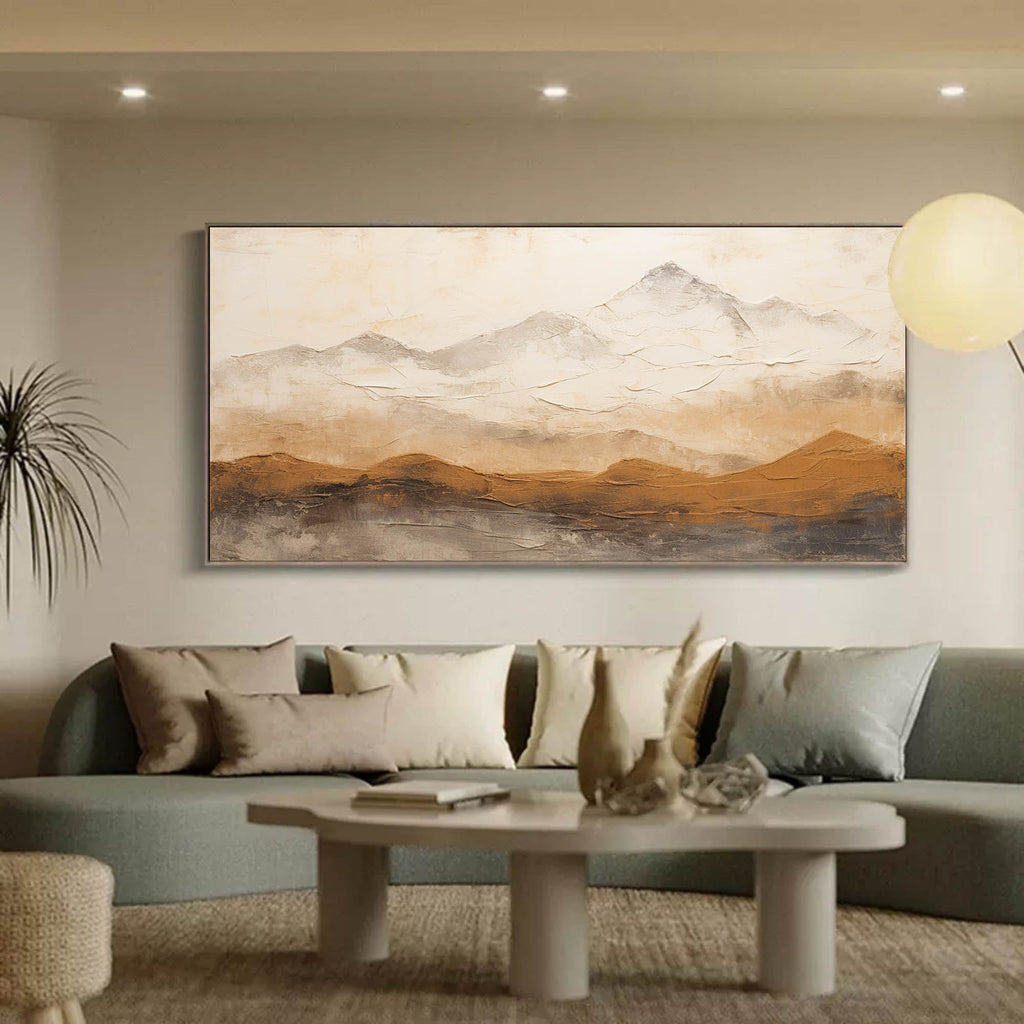 Large horizontal neutral landscape canvas artwork beautifully framed and hung above a living room sofa.