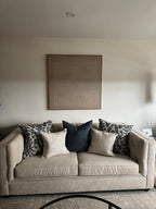 A beige wabi-sabi textured painting hangs above the sofa in the living room.