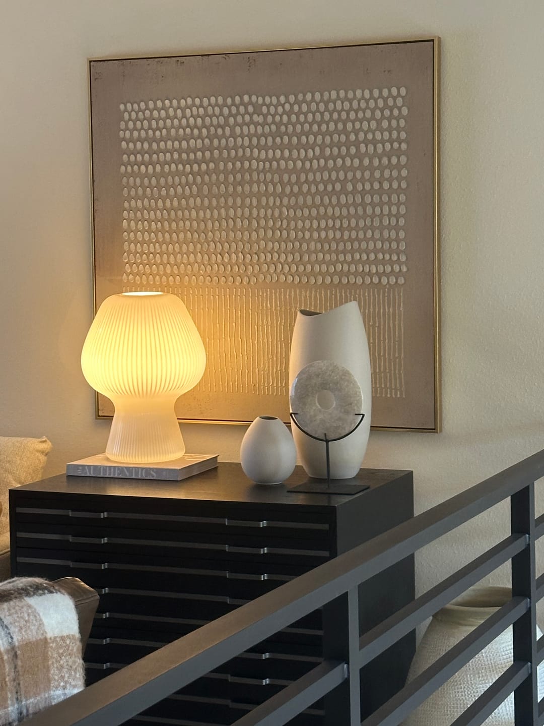 A beige Wabi-Sabi wall art piece hangs on the console table in the living room.