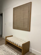 A large, square framed abstract art painting hanging above the entryway bench is the perfect decoration for the entryway.
