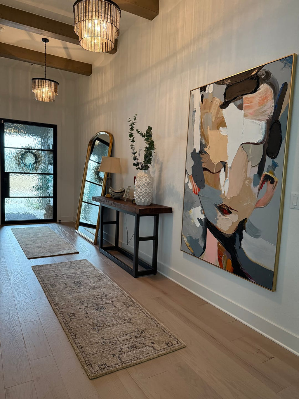 Abstract portrait textured wall art hangs in the entryway