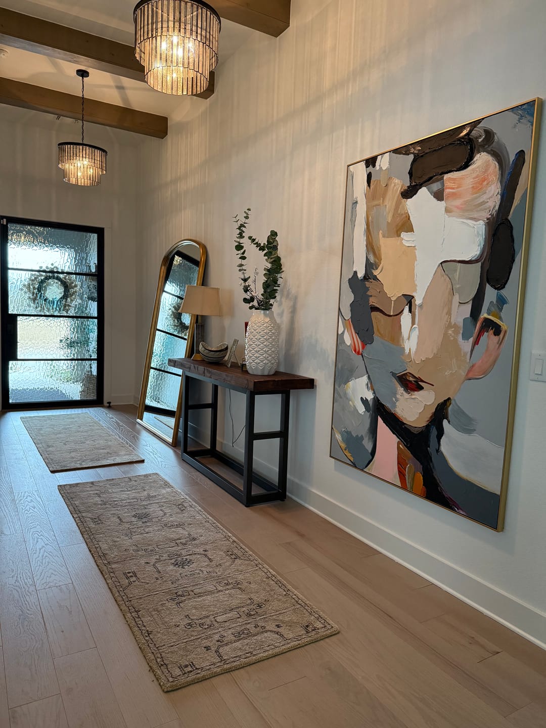 Abstract portrait textured wall art hangs in the entryway