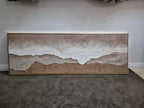 Modern beige and brown heavy-texture sea wave painting creating a serene aesthetic over a master living room.
