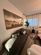 A large panoramic Wabi-Sabi beach abstract wall art painting hangs above the living room sofa, decorating the living room.