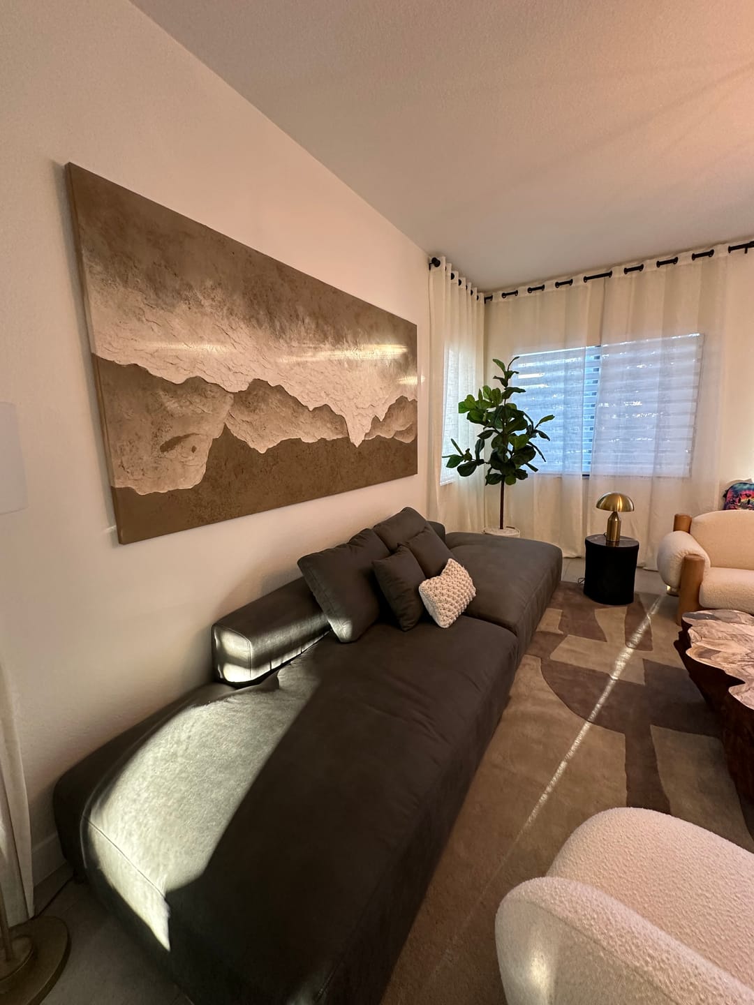 A large panoramic Wabi-Sabi beach abstract wall art painting hangs above the living room sofa, decorating the living room.