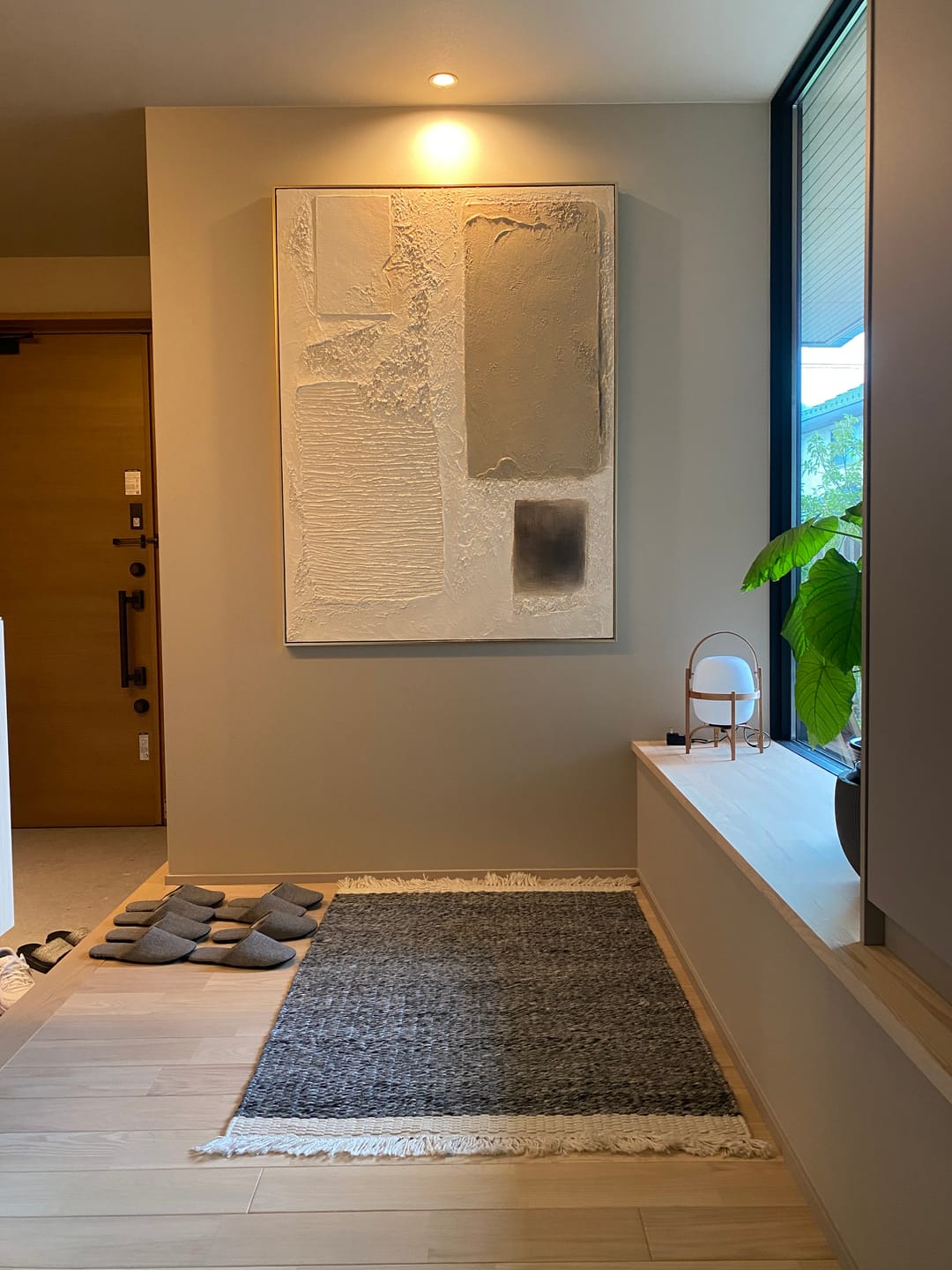 Large vertical heavy texture abstract artwork hanging on a contemporary entryway gallery wall