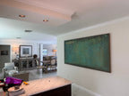 A large green Wabi-Sabi textured horizontal wall painting hangs on the restaurant wall.