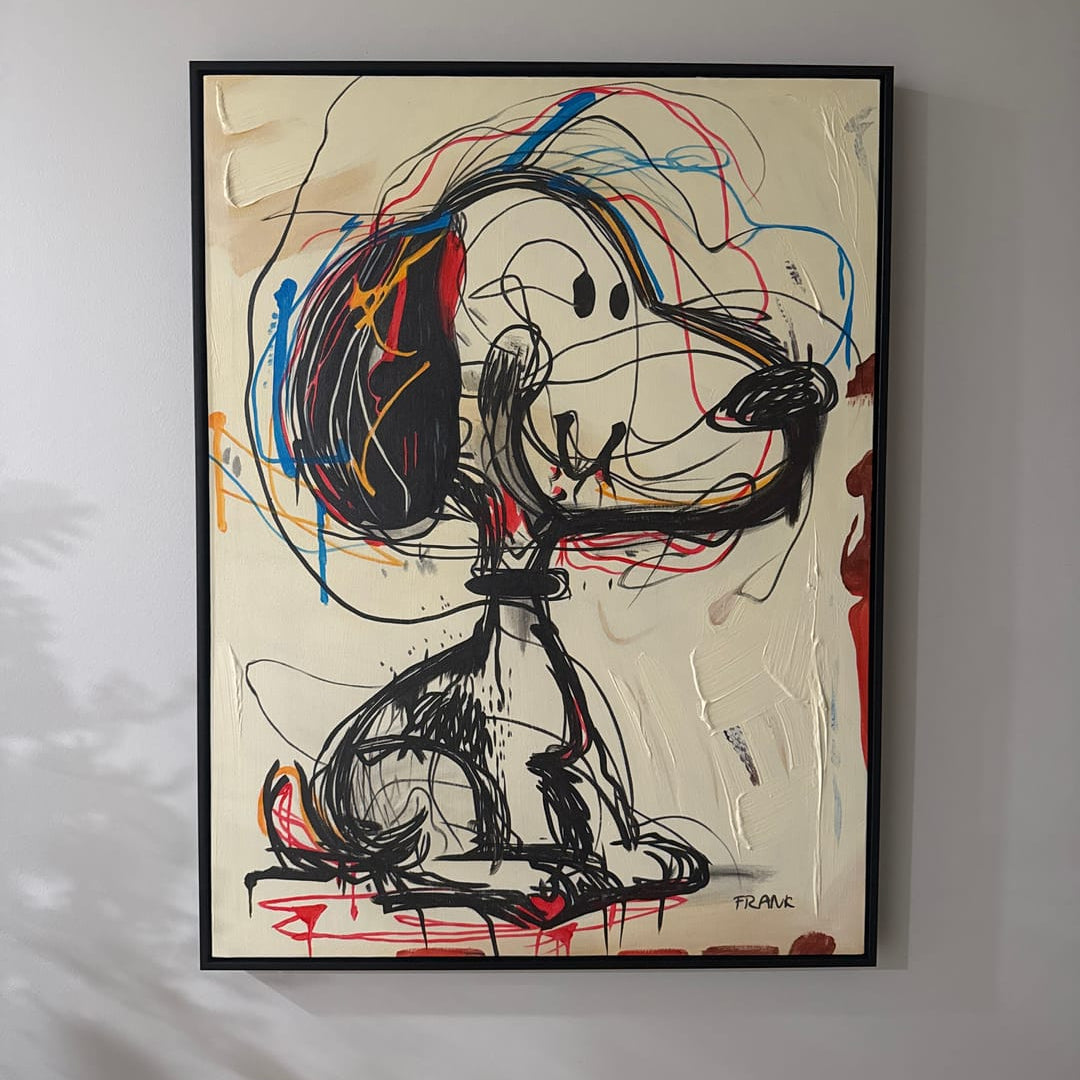 A framed abstract painting of Snoopy sitting down, rendered in black sketch lines with red, blue, orange, and yellow paint splatters on a cream background, hanging on the children's room wall.