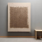 Large minimalist neutral grid canvas artwork beautifully framed and hung above a modern rustic living room sofa.