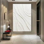 Large minimalist white textured canvas artwork beautifully framed above a modern living room sofa.
