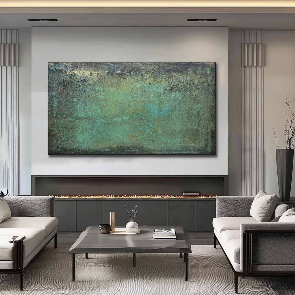 Large horizontal green abstract canvas artwork beautifully framed and hung above a modern rustic living room sofa.
